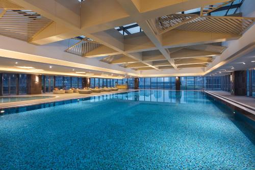 蘇州的住宿－蘇州盛捷白塘金融港服務公寓，一座大型游泳池,位于一座拥有大型天花板的建筑内