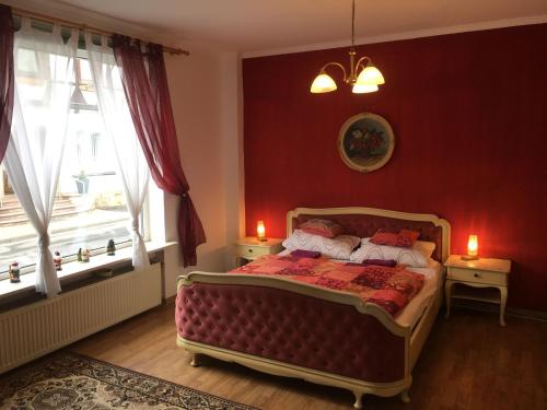 ヴァルデックにあるFerienhaus Seesternのベッドルーム1室(赤い壁のベッド1台、窓2つ付)