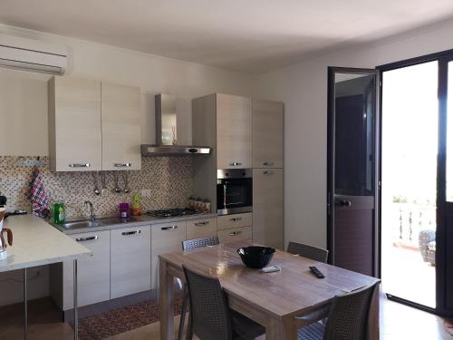 a kitchen with a wooden table and a dining room at Villa Sabbiadoro in Noto Marina