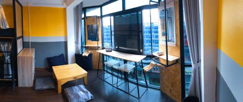 a room with a window with a desk and a table at U2 & i-smile Hostel in Chiang Mai