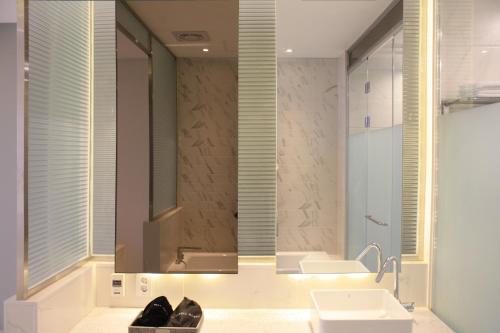 a bathroom with a sink and a mirror at Rosabell Hotel in Ansan