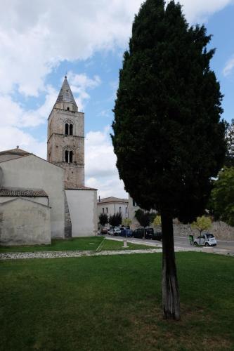 a tree in front of a church with a tower at Hostel il Tetto in Melfi