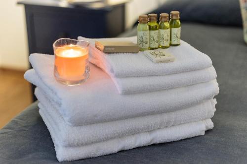 a pile of towels with a candle and bottles of wine at La Dimora Di Odisseo in Trapani