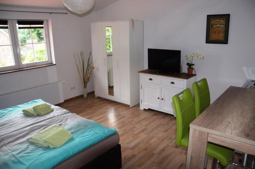 a room with a table and a bed and a television at Ferienresort Texas MV in Kirch Jesar