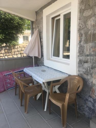 un tavolo e sedie su un patio con finestra di Studio Apartments Krasici a Tivat