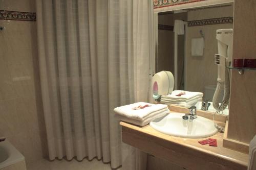 a bathroom with a sink and a shower curtain at Hostal Castilla in Benavente