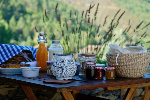 a picnic table with food and drinks on it at Quinta das Levadas - Country House & Nature in Alvoco das Várzeas