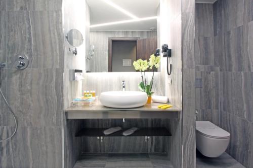 a bathroom with a sink and a toilet and a mirror at The Hive Hotel in Rome