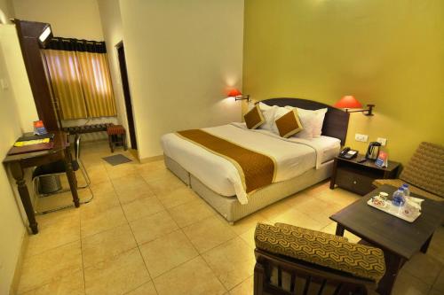 a hotel room with a large bed and a desk at Rajputana Palace in Jodhpur