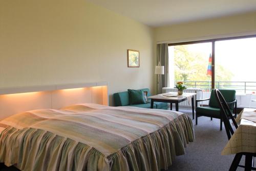 a hotel room with a bed and a table and chairs at Ferienhaus Uklei in Sielbeck