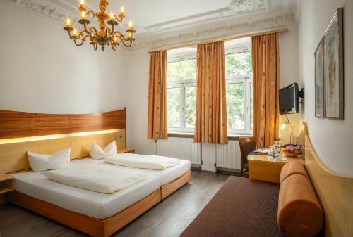 a bedroom with a bed and a chandelier at Hotel Spitzberg Garni in Passau