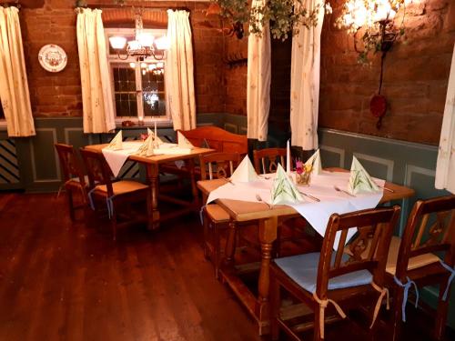 a dining room with tables and chairs with white tablecloths at Brauereigasthof Dachsenfranz in Zuzenhausen
