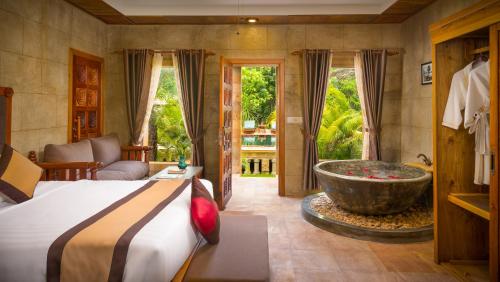 - une chambre avec un lit et une baignoire dans l'établissement Model Temple Resort & Spa, à Siem Reap