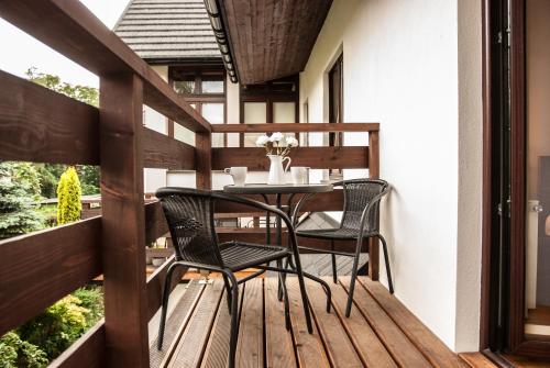 a patio with a table and chairs on a deck at Gimnazjalna 5 - Apartamenty i pokoje w Centrum Zakopanego in Zakopane