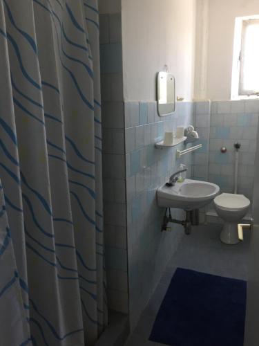 a bathroom with a sink and a toilet at Éva Apartman in Bük