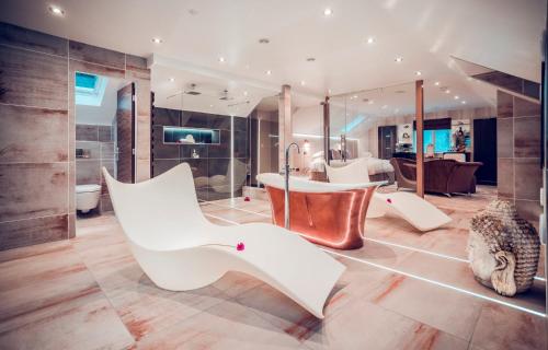 a living room with white furniture and a bathroom at Aphrodites Group - Luxury Hot Tub Suites in Central Lake District! in Bowness-on-Windermere