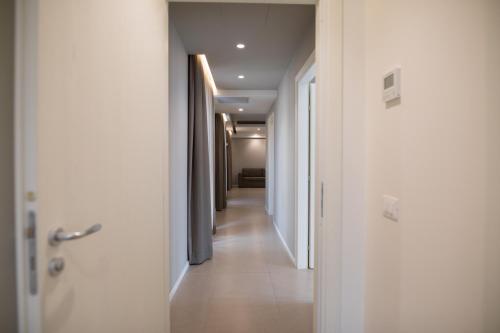 a hallway with white walls and a long corridor at Airone City Hotel in Catania