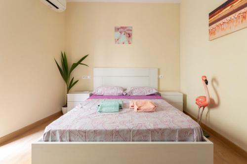 Flamingo Apartment في مالقة: غرفة نوم عليها سرير وفوط
