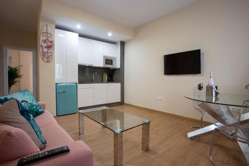 salon z kanapą i szklanym stołem w obiekcie Flamingo Apartment w Maladze