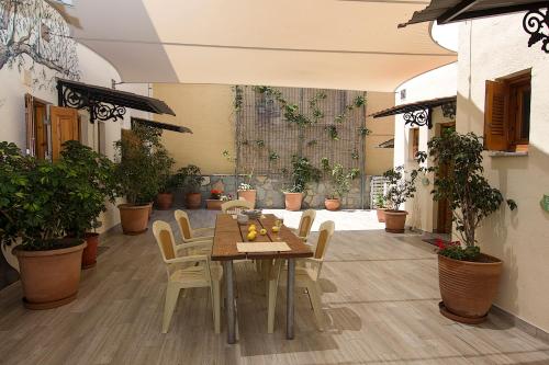 a table and chairs in a room with potted plants at Alkyoni Apartments in Agios Nikolaos