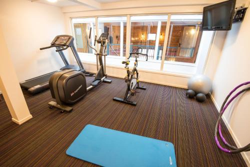 a gym with treadmills and exercise bikes in a room at Dolmsundet Hotell Hitra in Melandsjøen