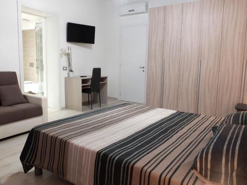 a bedroom with a bed and a desk and a chair at Centro Storico Rooms in Ferrara