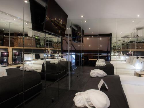 two beds in a room with glass walls at Hotel Betmanowska Main Square Residence Adults Only in Kraków