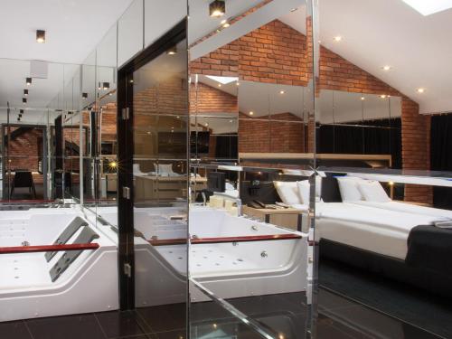 a room with a bed and a large glass wall at Hotel Betmanowska Main Square Residence Adults Only in Kraków