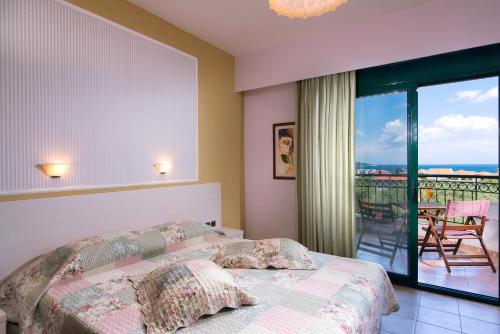 a bedroom with a bed and a balcony with a view at Ocean Beach Hotel in Skala Potamias