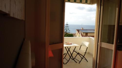 a balcony with a table and a view of the ocean at ele&gio accomodation in Tropea
