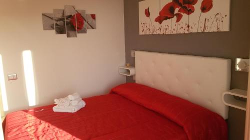 a bedroom with a red bed with a red blanket at ele&gio accomodation in Tropea