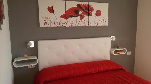 a bedroom with a bed with a red blanket at ele&gio accomodation in Tropea