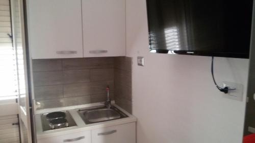 a kitchen with a sink and a white refrigerator at ele&gio accomodation in Tropea