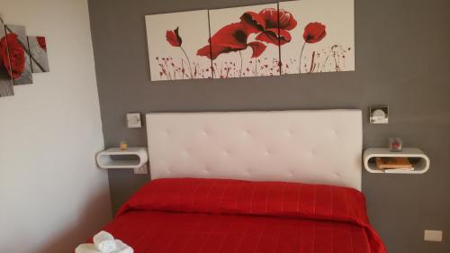 a bedroom with a bed with a red blanket at ele&gio accomodation in Tropea