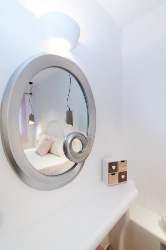 a mirror in a white room with a bed at Fouli's House at "Porto Vlastos" in Agios Ioannis Tinos