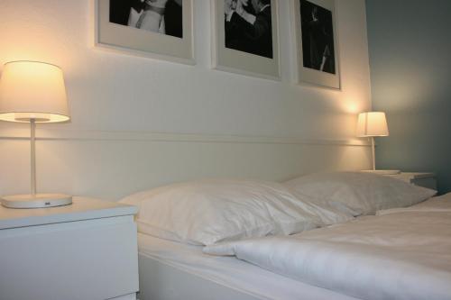 a bedroom with two white beds and two lamps at Storchencamp Gästehaus Purbach in Purbach am Neusiedlersee