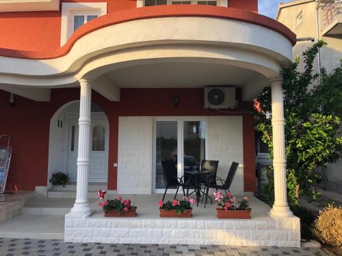 a porch of a house with chairs and flowers at Apartment Jopa in Šibenik