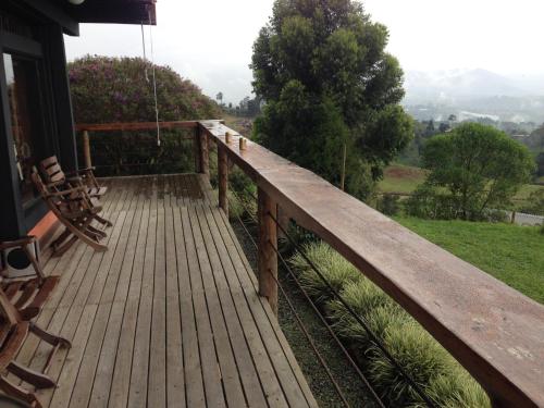 a wooden deck with chairs on a house at Santa Elena de la Colina in Filandia