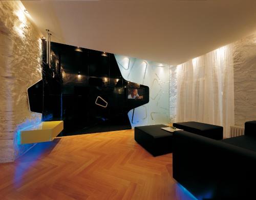 a living room with a couch and a flat screen tv at Hotel Aurora in Merano
