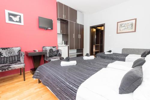 a bedroom with a large bed and a red wall at Villa Dudan LakeView in Ohrid