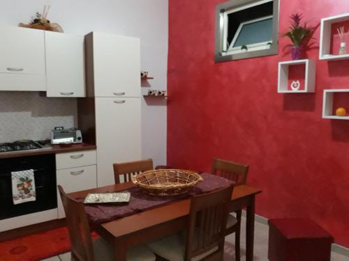 カステッランマーレ・デル・ゴルフォにあるCasa di Loryの赤い壁のキッチン(テーブル付)