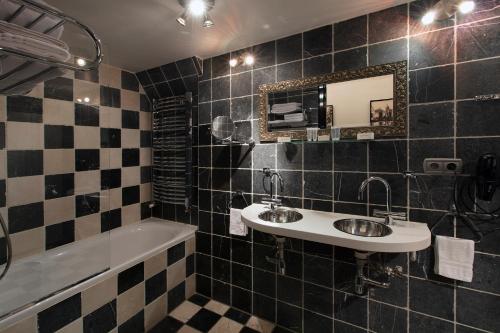 a bathroom with two sinks and a tub and a mirror at Dutch Masters Short Stay Apartments in Amsterdam