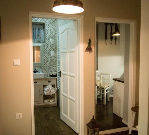 a kitchen with a white door and a dining room at Feliz apartman in Gyula