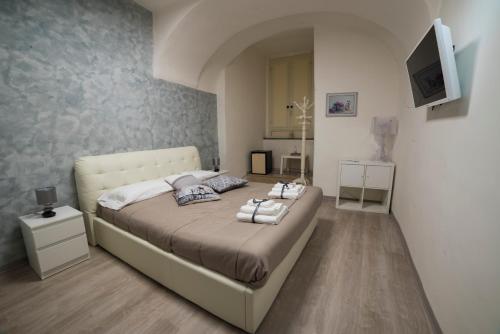 1 dormitorio con 1 cama y TV en la pared en Almayer La Locanda, en Gaeta
