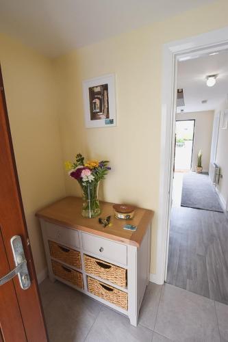 a vase of flowers on a dresser in a room at Hillyard Mews in Newcastle