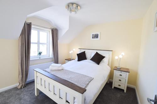 a bedroom with a white bed and a window at Hillyard Mews in Newcastle