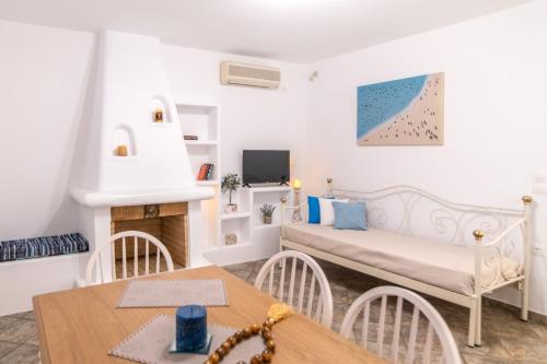 a small living room with a bed and a table at Fouli's House at "Porto Vlastos" in Agios Ioannis Tinos