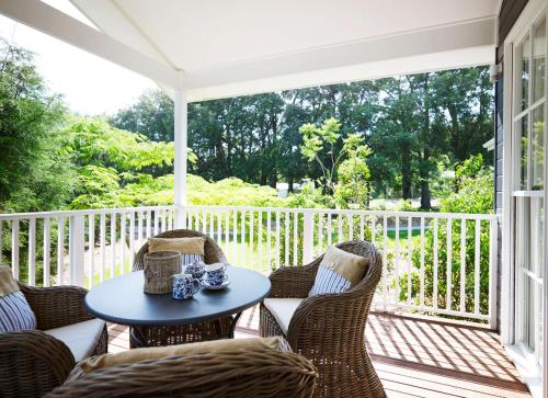 a patio with a table and chairs on a porch at Bells at Killcare Boutique Hotel, Restaurant & Spa in Killcare