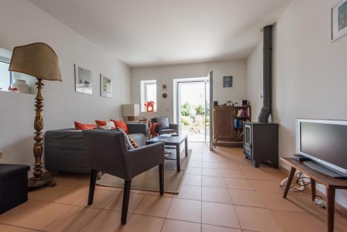 a living room with a couch and a tv at Casa do Olival in Figueiró dos Vinhos