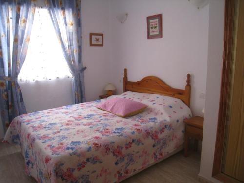 トレビエハにあるApartamento Pascualのベッドルーム1室(花柄のベッドカバー、窓付)